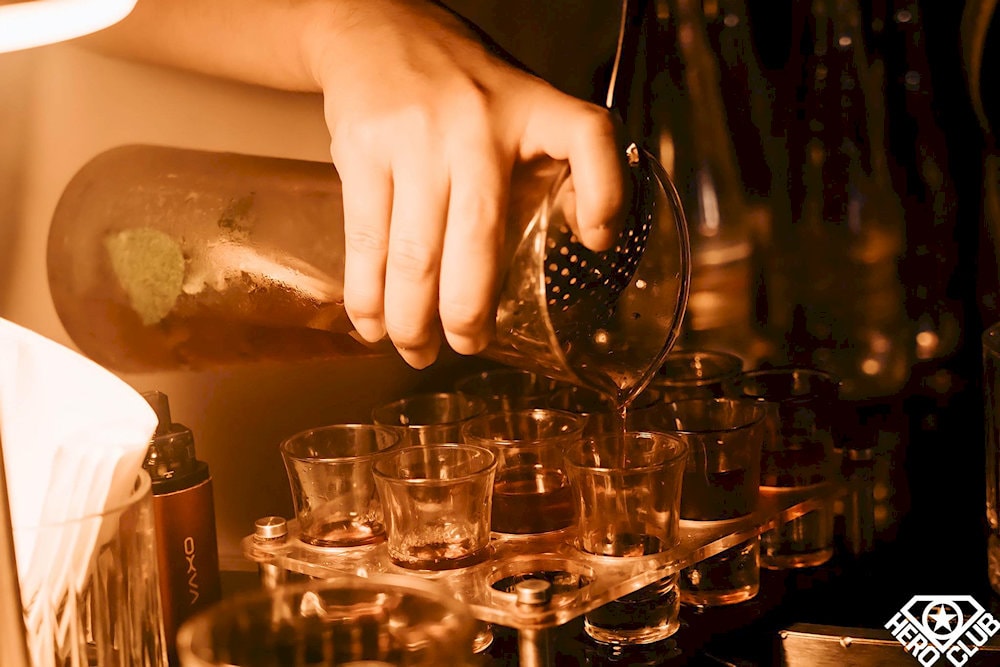 A bartender at HERO Club prepares a round of vibrant for an unforgettable night